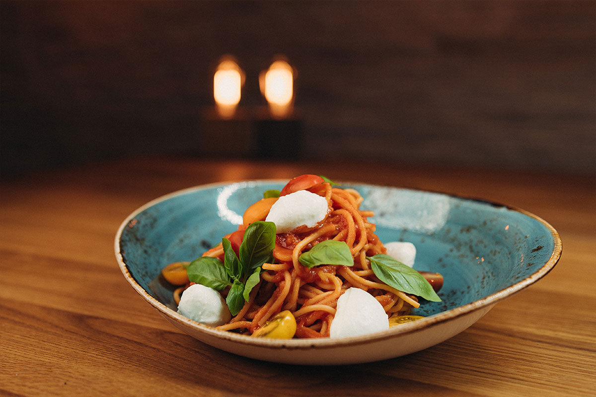 Spaghetti Caprese mit hausgemachter Tomatensauce, Babymozzarella, Tomaten und Basilikum