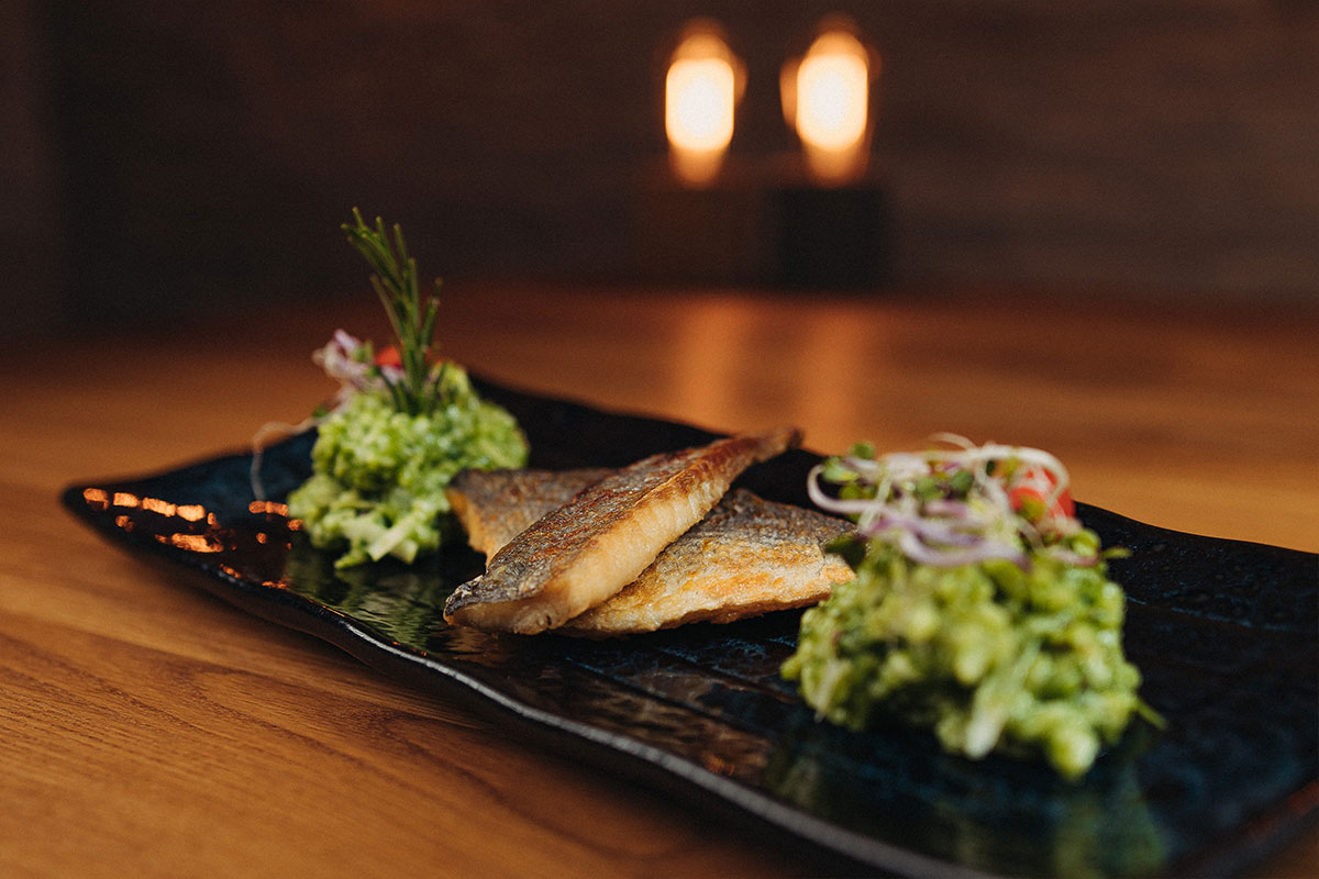 Auf der Haut gebratene Doradenfilets mit saisonal abgeschmecktem Risotto, dazu Salatnest und Sesamcreme