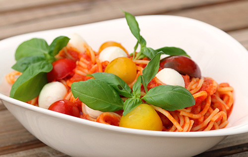 Spaghetti Caprese mit hausgemachter Tomatensauce, Babymozzarella, Tomaten und Basilikum