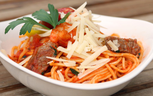 Spaghetti Reef & Beef mit Garnelen und Rindersteakstreifen in einer Tomatensauce, Petersilie und Grana Padano D.O.P